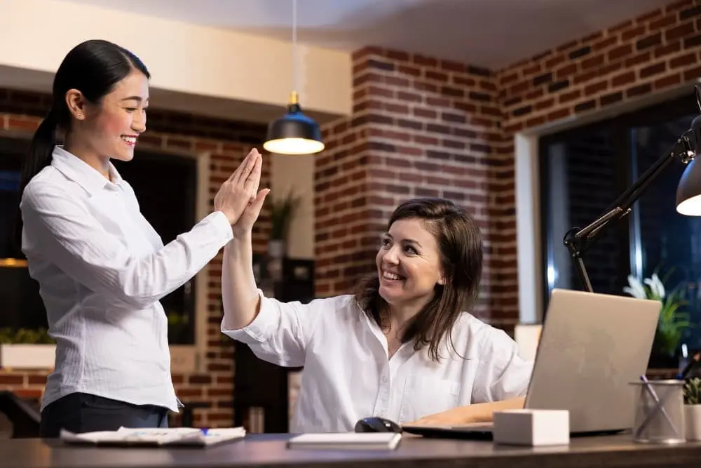 2 woman high fiving